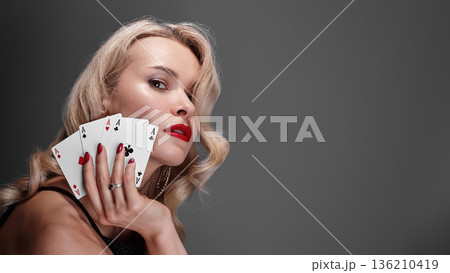 Sophisticated Woman Displaying Confidence. Refined Lady With Vibrant Nail Polish And Playing Cards. Chic Blonde Woman Confidently Posing With Red Nails And Winning Poker Hand In Lavish Setting Sophisticated Woman Displaying Confidence. Refined Lady With Vibrant Nail Polish And Playing Cards. Chic Blonde Woman Confidently Posing With Red Nails And Winning Poker Hand In Lavish Setting 136210419