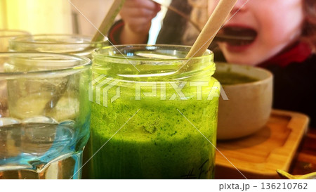 Child eating green vegetable soup 136210762