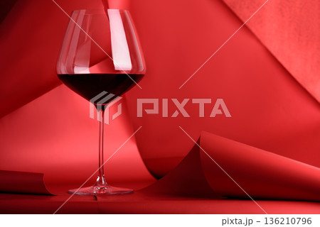 Red Wine Glass on Sculptural Red Background. Elegant Monochrome Still Life Red Wine Glass on Sculptural Red Background. Elegant Monochrome Still Life 136210796