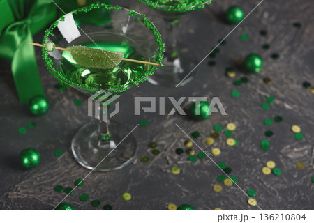 Green Cocktails with Lime,  Gifts and Confetti. Festive St. Patricks Day Celebration Still Life 136210804