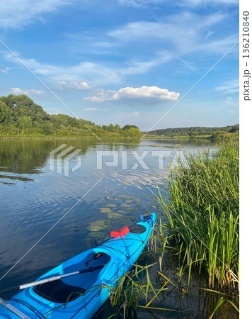 A person is paddling a surfboard on a lake A person is paddling a surfboard on a lake 136210840