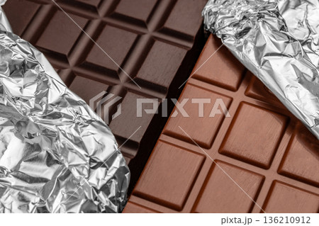 Dark and milk chocolate bars with foil close up Dark and milk chocolate bars with foil close up 136210912