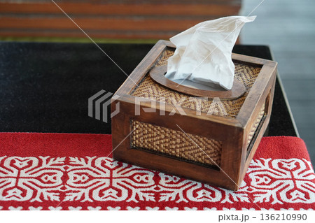 closeup white tissues are in a rectangular wooden and bamboo box on the red carpet on the black marble table, nature background, object, decor, copy space closeup white tissues are in a rectangular wooden and bamboo box on the red carpet on the black marble table, nature background, object, decor, copy space 136210990