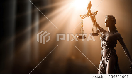 Statue of a woman holding scales. The statue is in front of a building. The statue is lit up by the sun Statue of a woman holding scales. The statue is in front of a building. The statue is lit up by the sun 136211001