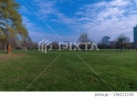 Wide green lawn in Donaupark Vienna with trees and modern skyline. Vienna, Austria Wide green lawn in Donaupark Vienna with trees and modern skyline. Vienna, Austria 136211130
