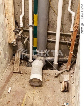 Old toilet in a dilapidated house with exposed plumbing and debris, showcasing the need for extensive renovations and restoration in a neglected bathroom environment Old toilet in a dilapidated house with exposed plumbing and debris, showcasing the need for extensive renovations and restoration in a neglected bathroom environment 136211284