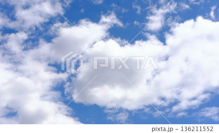 Bright blue sky filled with fluffy white clouds, creating a serene atmosphere, ideal for backgrounds or nature-themed projects, showcasing the beauty of the sky Bright blue sky filled with fluffy white clouds, creating a serene atmosphere, ideal for backgrounds or nature-themed projects, showcasing the beauty of the sky 136211552
