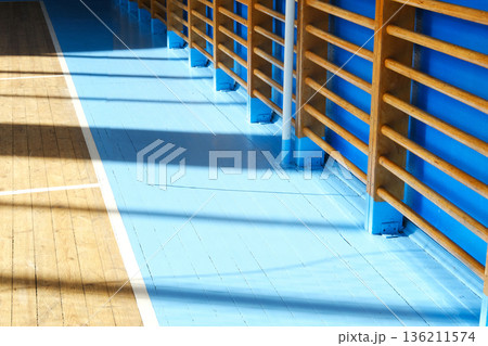 School gym interior showcasing polished wooden floor and blue walls, emphasizing sports activities for children and adolescents in a vibrant educational environment 136211574