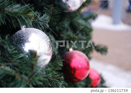 Christmas tree adorned with shiny silver and red ornaments, creating a festive atmosphere, perfect for holiday postcards and seasonal greetings with copy space 136211739