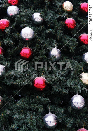 Christmas tree adorned with vibrant red, silver, and gold ornaments, showcasing festive decorations that evoke holiday spirit and joy during the New Year celebration season 136211746