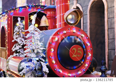 Colorful festive train decorated with lights and artificial snow, featuring a prominent number 25, creating a cheerful holiday atmosphere for seasonal celebrations 136211785
