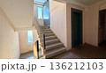 Residential apartment building stairwell with concrete stairs, metal railings and windows 136212103