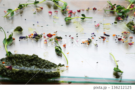Leftover food remnants on a glass surface, showcasing vibrant colors and textures, highlighting the concept of food waste disposal and the impact of culinary excess Leftover food remnants on a glass surface, showcasing vibrant colors and textures, highlighting the concept of food waste disposal and the impact of culinary excess 136212125
