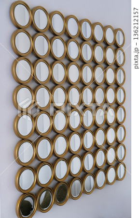 Decorative wall arrangement featuring multiple round mirrors in gold frames, creating a unique visual display that enhances interior aesthetics and reflects light beautifully Decorative wall arrangement featuring multiple round mirrors in gold frames, creating a unique visual display that enhances interior aesthetics and reflects light beautifully 136212157