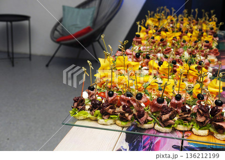 Colorful platter of gourmet appetizers featuring fresh vegetables, meats, and garnishes, beautifully arranged for catering at an upscale event with elegant presentation Colorful platter of gourmet appetizers featuring fresh vegetables, meats, and garnishes, beautifully arranged for catering at an upscale event with elegant presentation 136212199