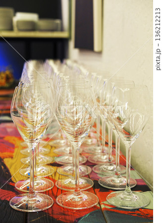 Elegant row of sparkling wine glasses arranged on a colorful table, showcasing the refined atmosphere of a catering event with attention to detail and presentation Elegant row of sparkling wine glasses arranged on a colorful table, showcasing the refined atmosphere of a catering event with attention to detail and presentation 136212213