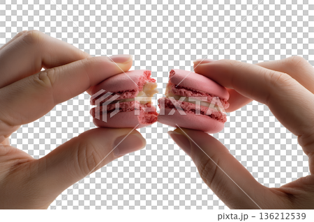 Close-up of hands gently breaking a pink macaron in half, revealing a creamy filling. Perfect for food blogs, patisserie ads, and delicate dessert concepts Close-up of hands gently breaking a pink macaron in half, revealing a creamy filling. Perfect for food blogs, patisserie ads, and delicate dessert concepts 136212539