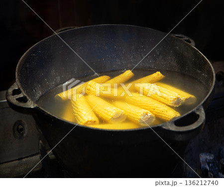 Yellow corn is cooked in a large cauldron Yellow corn is cooked in a large cauldron 136212740