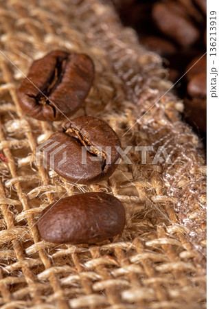 Close-up of coffee beans artfully arranged on a rustic burlap napkin Close-up of coffee beans artfully arranged on a rustic burlap napkin 136213919