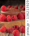 Delicious chocolate muffins elegantly decorated with fresh ripe raspberries 136213929