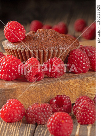 Delicious chocolate muffins elegantly decorated with fresh ripe raspberries Delicious chocolate muffins elegantly decorated with fresh ripe raspberries 136213929