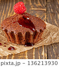 Delicious chocolate muffin topped with fresh raspberries close-up view 136213930