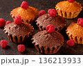 Delicious muffins and ripe raspberries displayed on a stylish black kitchen table 136213933