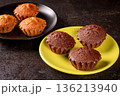 Delicious chocolate and lemon muffins ready to indulge on plates 136213940