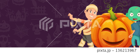 A boy is standing next to a pumpkin and smiling 136213967