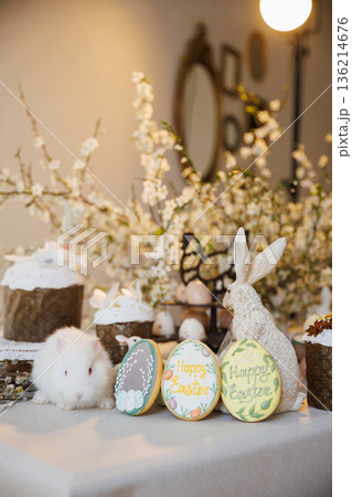 Easter still life with white bunny, Happy Easter cookies and spring blossoms Easter still life with white bunny, Happy Easter cookies and spring blossoms 136214676