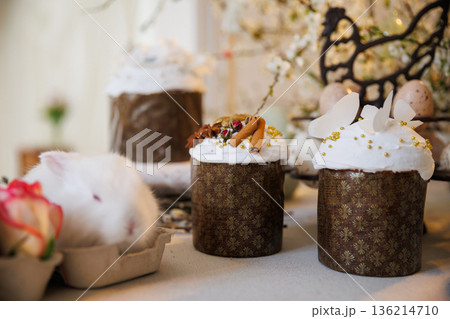 Easter cakes with icing, spices and white bunny, cozy spring still life Easter cakes with icing, spices and white bunny, cozy spring still life 136214710