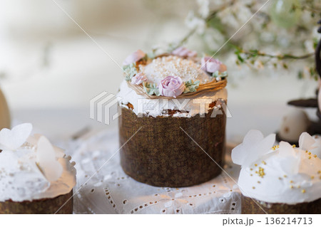 Easter cakes and eggs on lace table with spring blossom branches, soft daylight 136214713