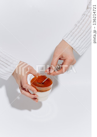 Hands tasting panna cotta with passion fruit topping on white background 136214721