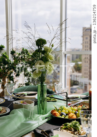 Green floral centerpiece on elegant banquet table with city view, natural light Green floral centerpiece on elegant banquet table with city view, natural light 136214759
