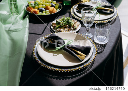 Elegant green and black restaurant tablescape with candelabra and gold accents Elegant green and black restaurant tablescape with candelabra and gold accents 136214760