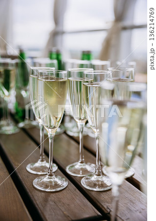 Champagne flutes with sparkling wine on wooden table, festive celebration Champagne flutes with sparkling wine on wooden table, festive celebration 136214769