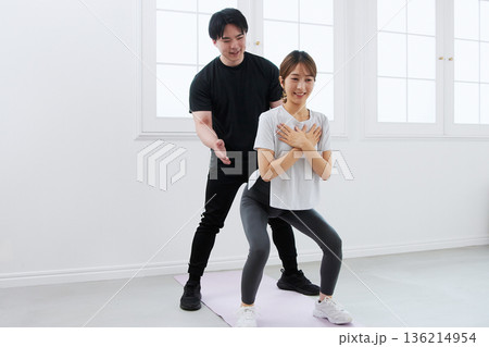 パーソナルトレーナーにトレーニングを受ける若い女性 パーソナルトレーナーにトレーニングを受ける若い女性 136214954