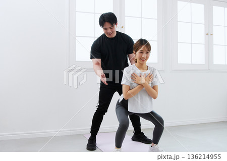 パーソナルトレーナーにトレーニングを受ける若い女性 パーソナルトレーナーにトレーニングを受ける若い女性 136214955