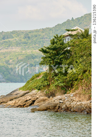 Thailand's coast on a sunny day, villas and hotels among palm trees on a hill, people on a jet ski, a yacht off the coast Thailand's coast on a sunny day, villas and hotels among palm trees on a hill, people on a jet ski, a yacht off the coast 136215390