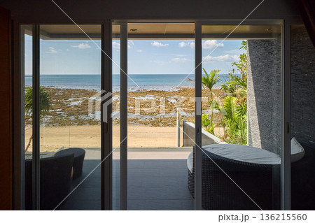 View from luxury villa at sunny day, sun loungers for sunbathing, umbrellas from the sun, pillows for swimming in the pool, palm tree on background View from luxury villa at sunny day, sun loungers for sunbathing, umbrellas from the sun, pillows for swimming in the pool, palm tree on background 136215560