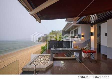 a palm tree by the pool in a luxury villa and the sea, it is raining heavily in the background, a palm tree by the pool in a luxury villa and the sea, it is raining heavily in the background, 136215567