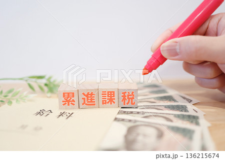 給料と紙幣で示す累進課税と税負担のイメージ。 給料と紙幣で示す累進課税と税負担のイメージ。 136215674