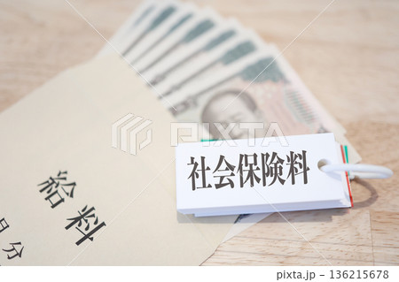 給料袋と紙幣。社会保険料を示すカード。 136215678