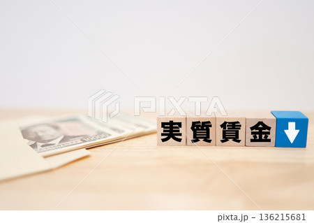 実質賃金低下を示す下矢印と紙幣のイメージ。 実質賃金低下を示す下矢印と紙幣のイメージ。 136215681