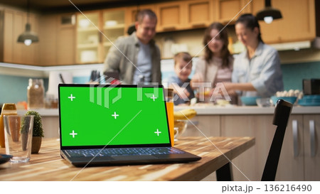 Mockup screen on laptop with cheerful family making homemade pizza, cooking in a cozy kitchen. Parents and kids laugh while adding mozzarella and vegetables, weekend bonding. 136216490