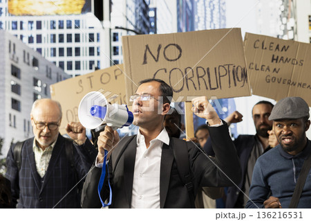 Large crowd of diverse protesters taking action against corrupt government, posters with messages like stop corruption, freedom and equal rights during a non-violent demonstration. Large crowd of diverse protesters taking action against corrupt government, posters with messages like stop corruption, freedom and equal rights during a non-violent demonstration. 136216531