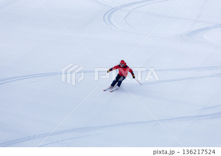 新雪のゲレンデにシュプールを描くスキーヤー 136217524