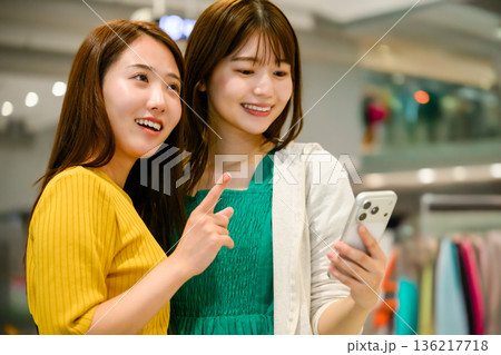 スマホを見ながら買い物する友人 ■撮影協力:関西国際空港(KIX) スマホを見ながら買い物する友人 ■撮影協力:関西国際空港(KIX) 136217718