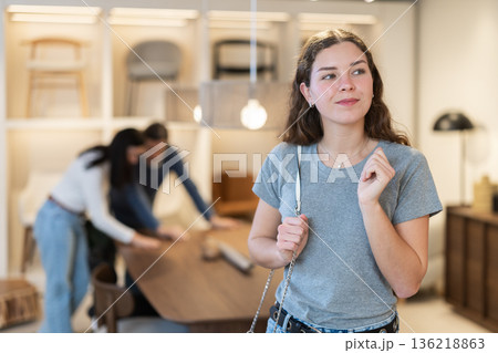 Woman buyer chooses furniture in furniture store 136218863