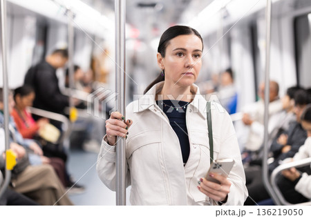 Woman with phone stand in metro carriage. Woman with phone stand in metro carriage. 136219050